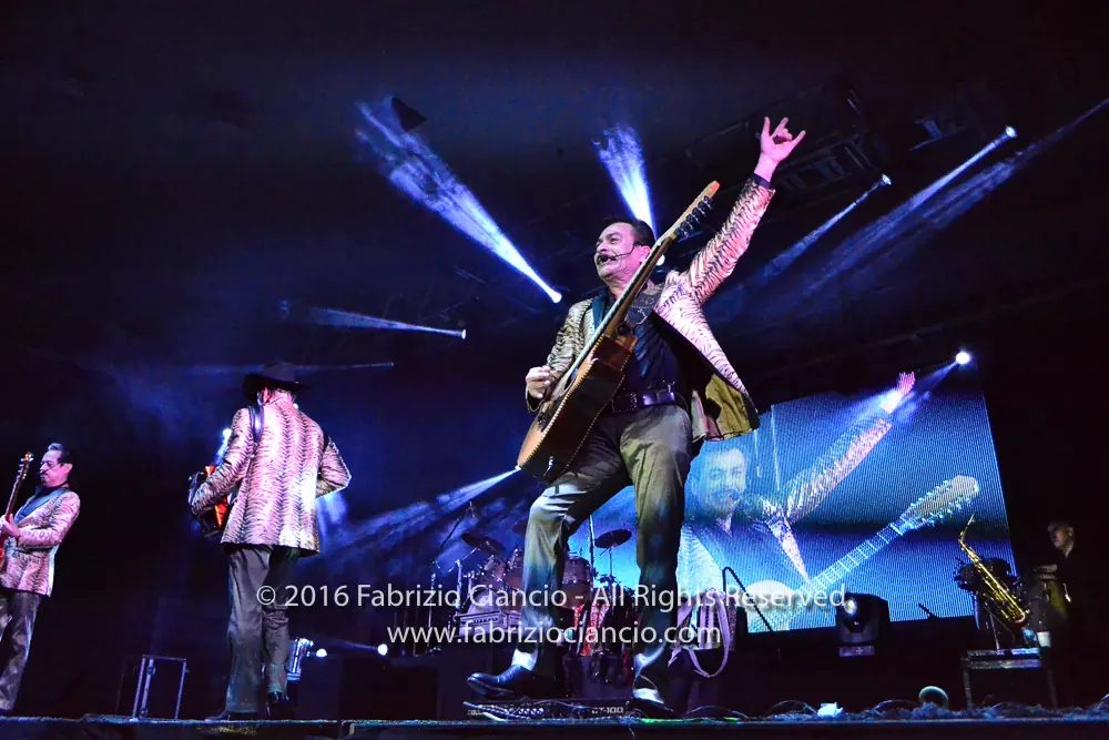 Musicians performing beneath dramatic stage lights